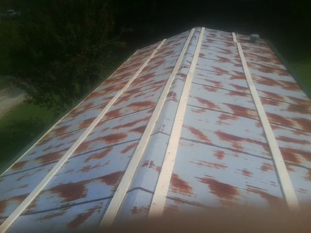 Rusted metal roof panels with new wood purlins before replacement — Storm Damage Roof Repair in West Alexandria by Roofing Brothers